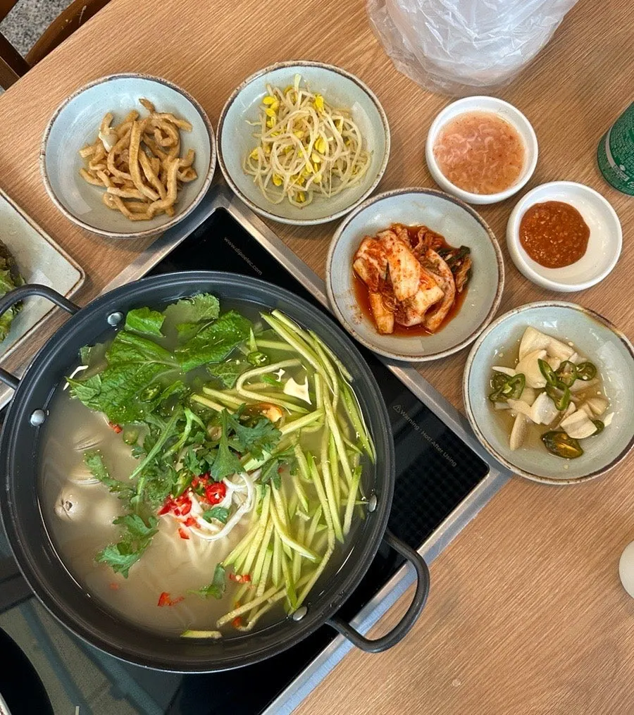 A wrap of bossam with radish salad and white kimchi