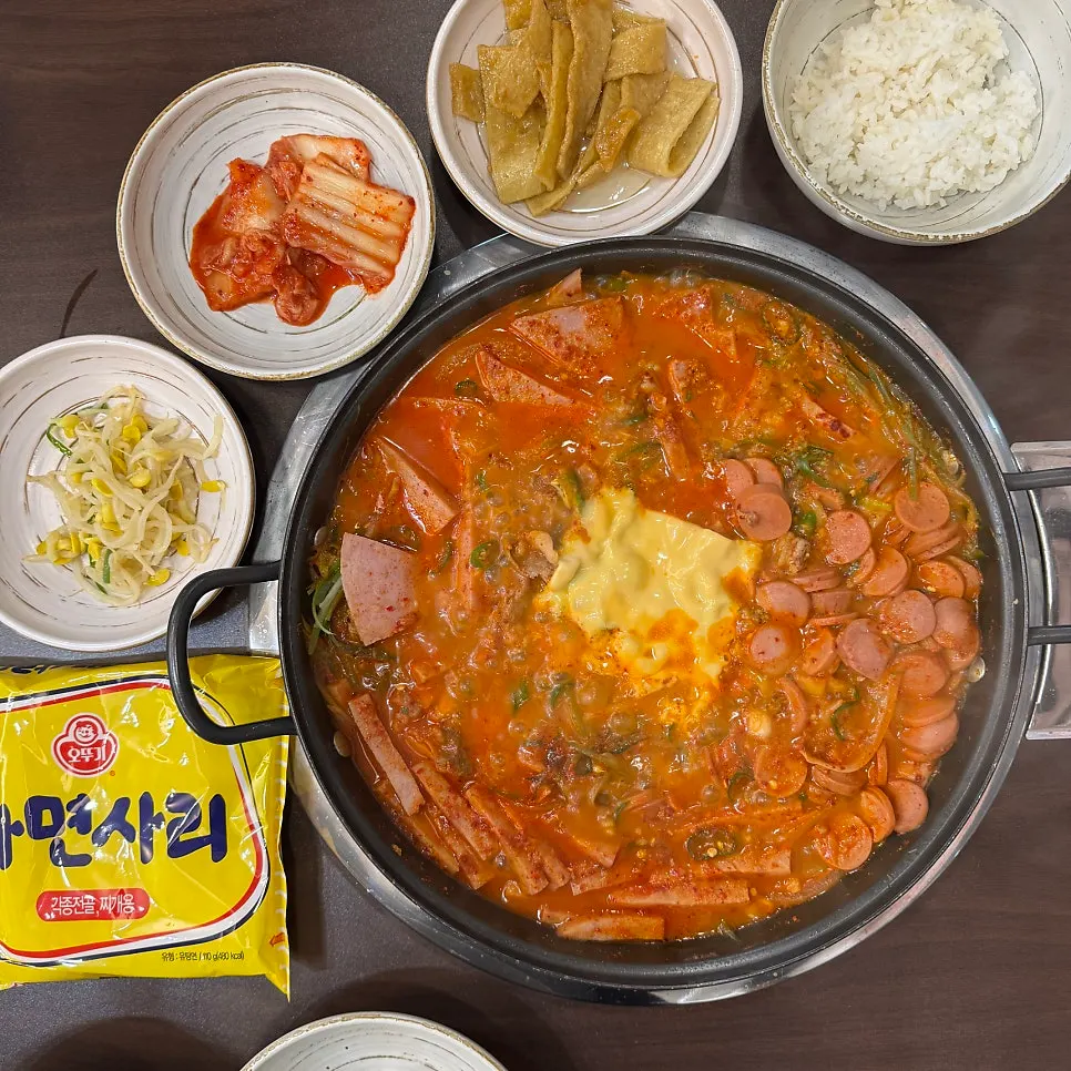 Budae-jjigae spread served with side dishes