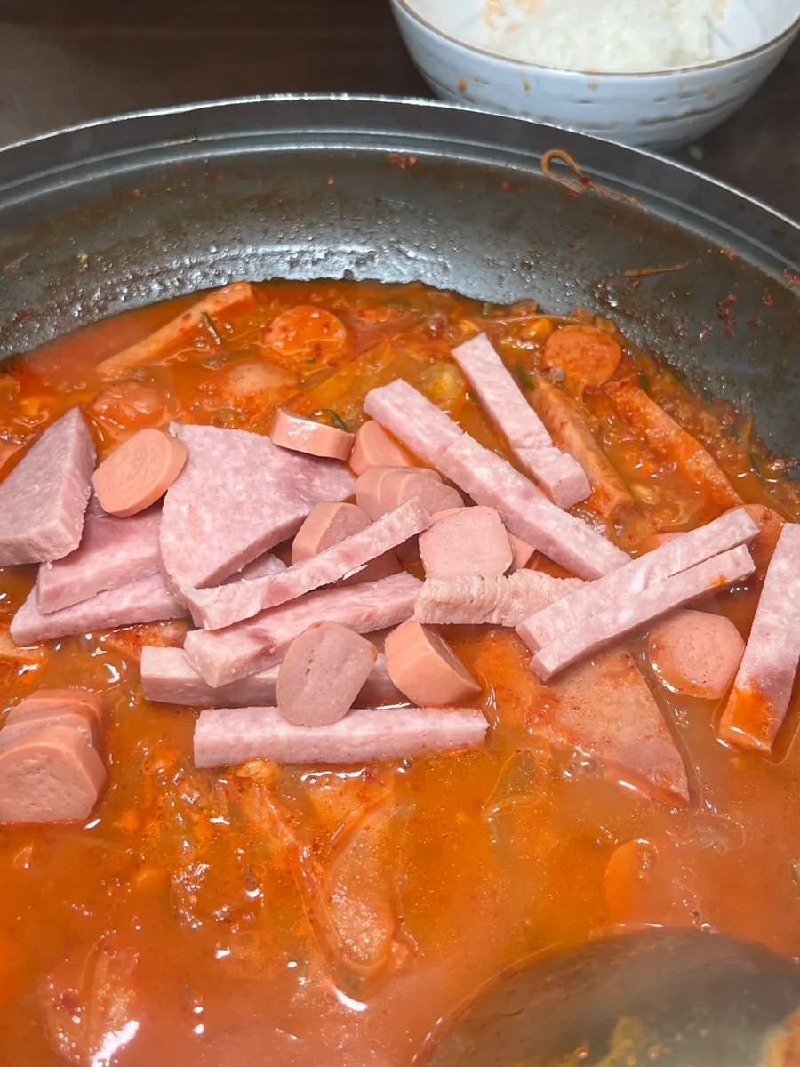 A bowl of rice with a spoonful of budae-jjigae