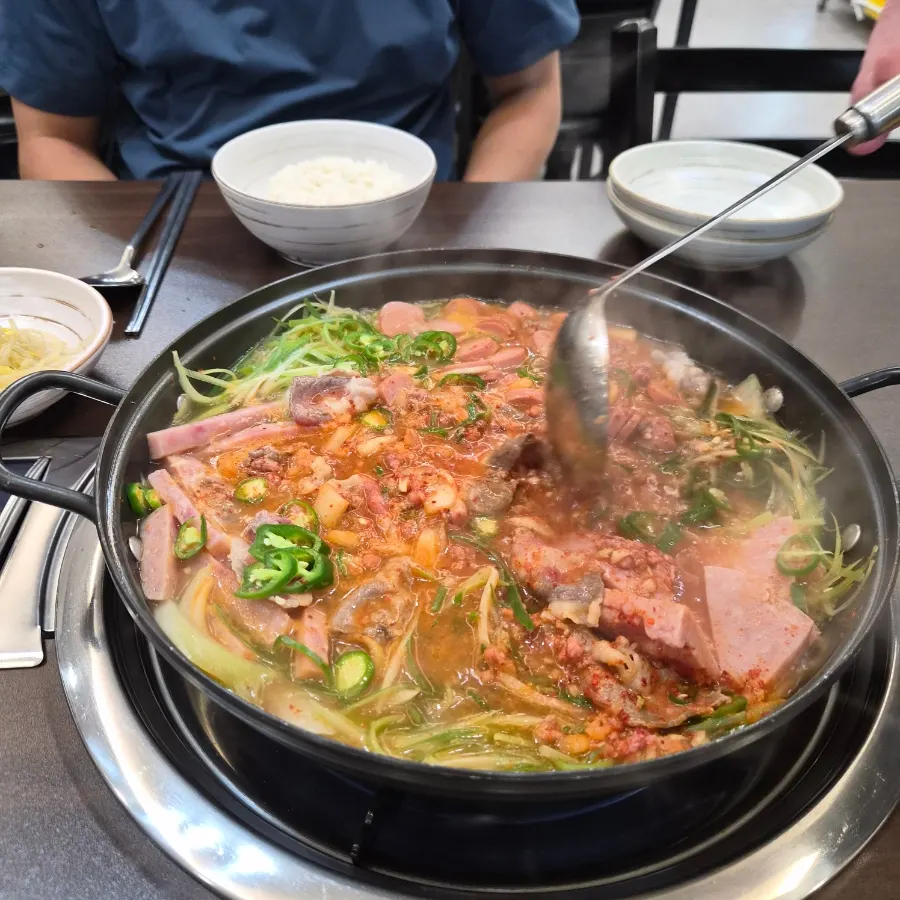 Banchan spread with kimchi, seasoned bean sprouts, stir-fried fish cake, and watermelon