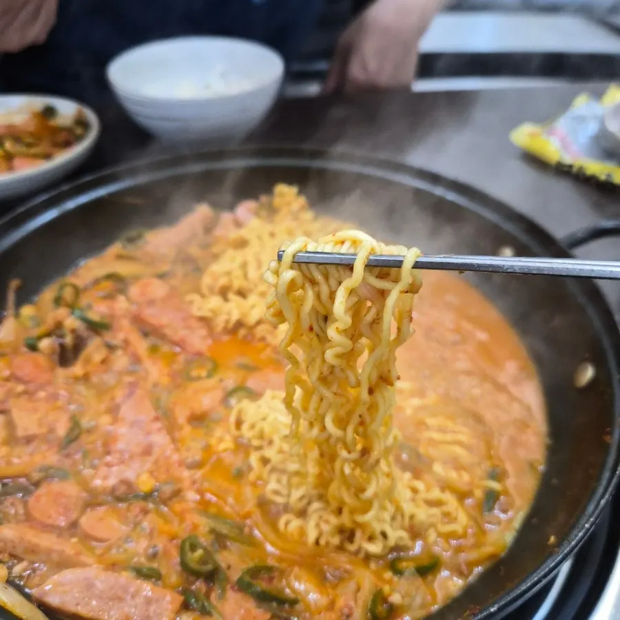 Ramyeon noodles added into the budae-jjigae pot