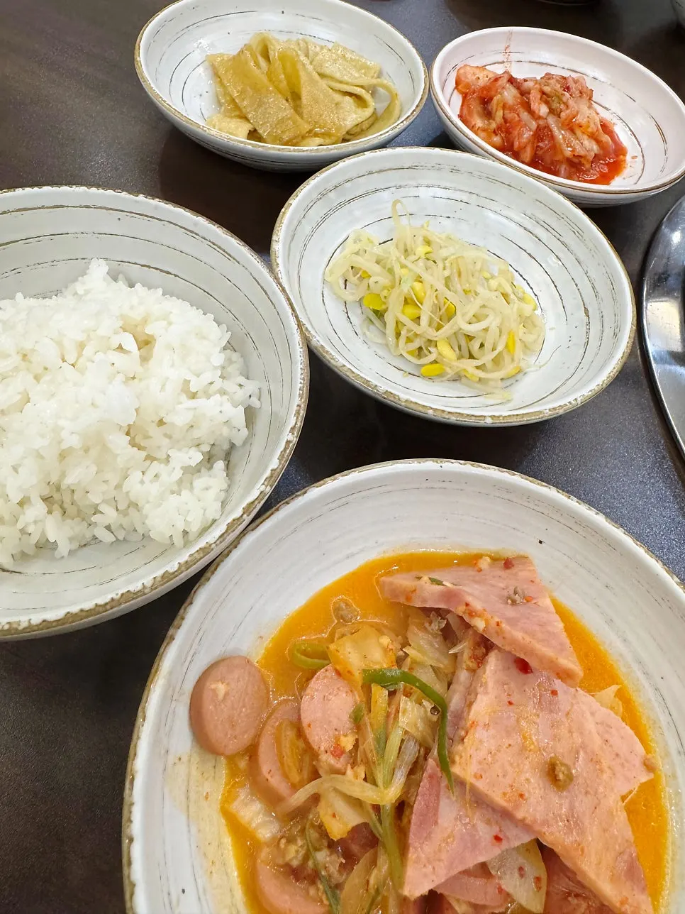 A ladleful of budae-jjigae ingredients scooped up