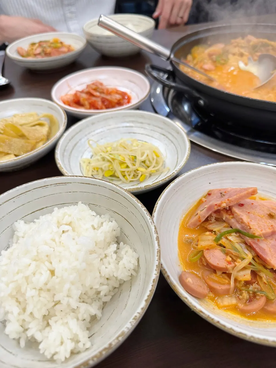 Basic side dishes of kimchi, seasoned bean sprouts, fish cake, and a bowl of rice
