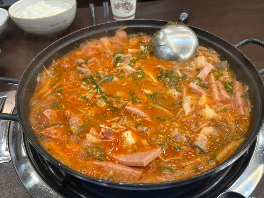 흰쌀밥 위에 올린 햄과 부대찌개 국물