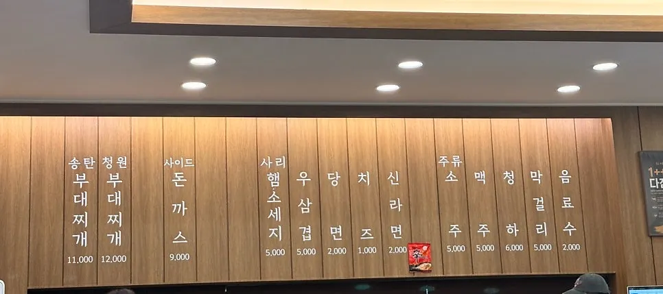 Menu board for budae-jjigae and add-ons at Cheongwon Restaurant