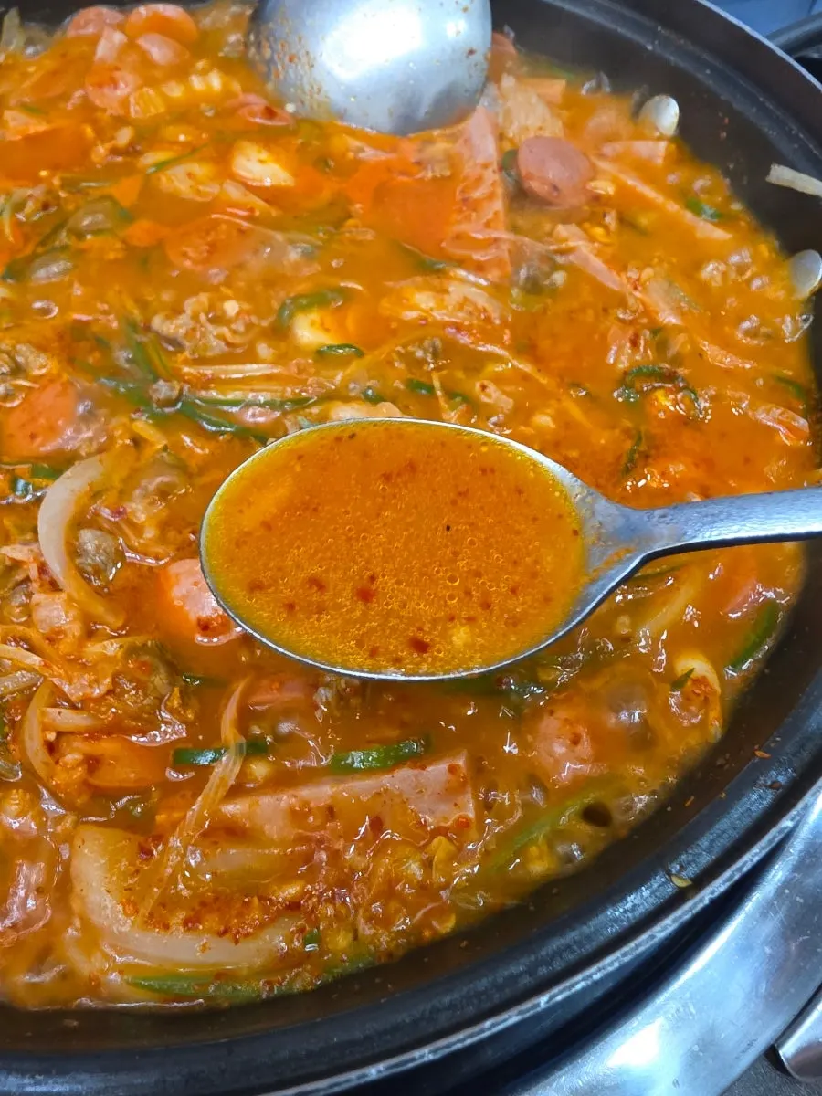 국물을 숟가락으로 떠올린 부대찌개
