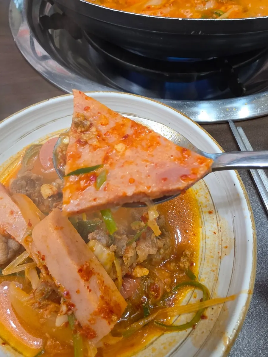 햄과 우삼겹을 밥에 올린 한 숟갈