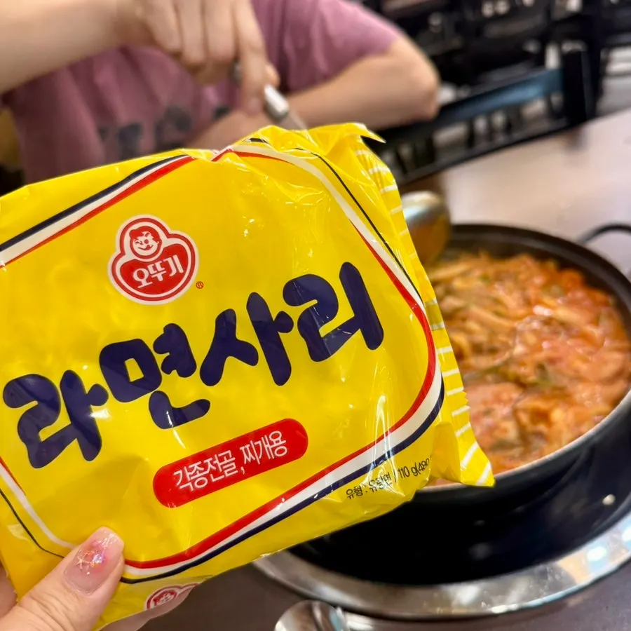 Broth-soaked glass noodles lifted out of the pot