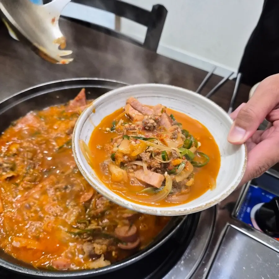 Budae-jjigae broth simmering after staff stirred it