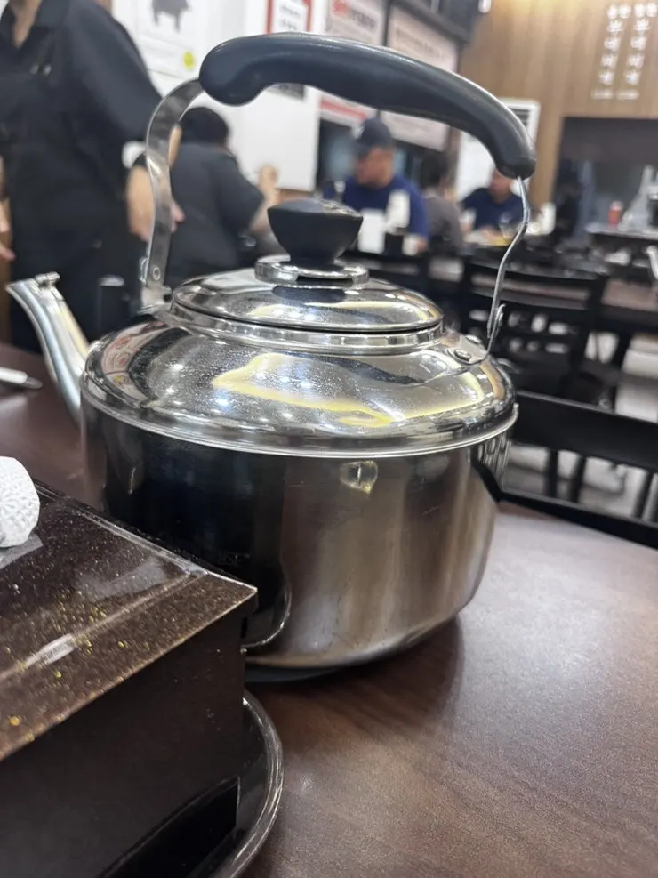 Budae-jjigae broth refill served in a kettle
