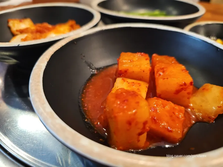 Table set with basic side dishes including diced radish kimchi and cabbage kimchi