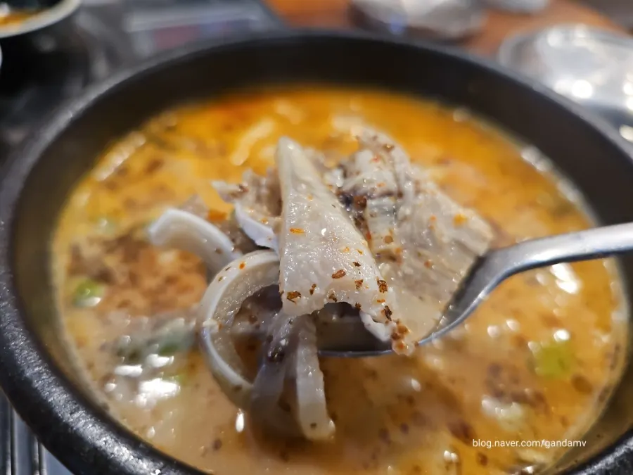 A spoonful of broth lifted from the sundae gukbap