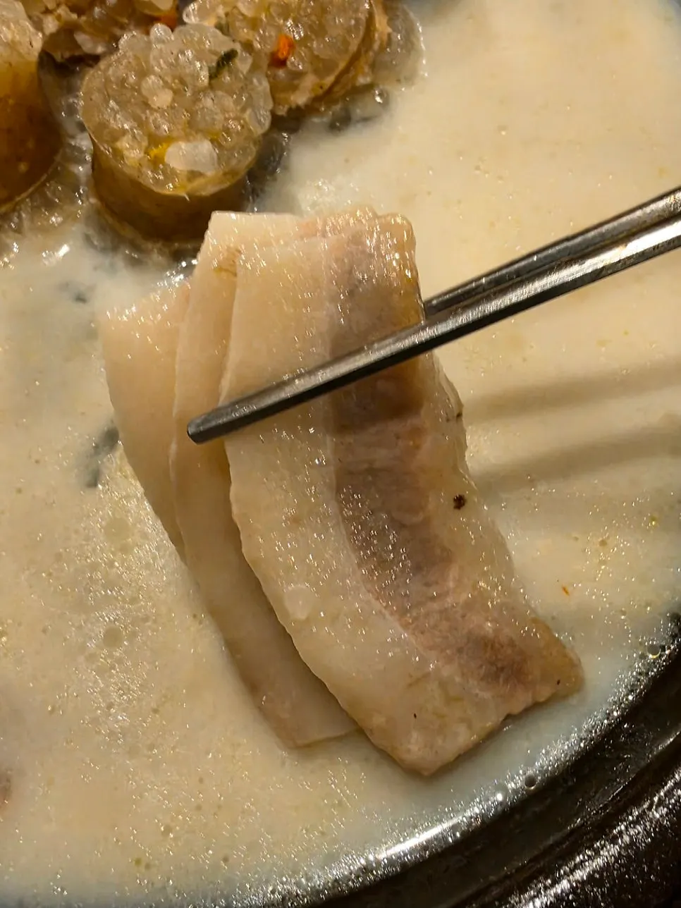 젓가락으로 집어 올린 부드러운 항정수육