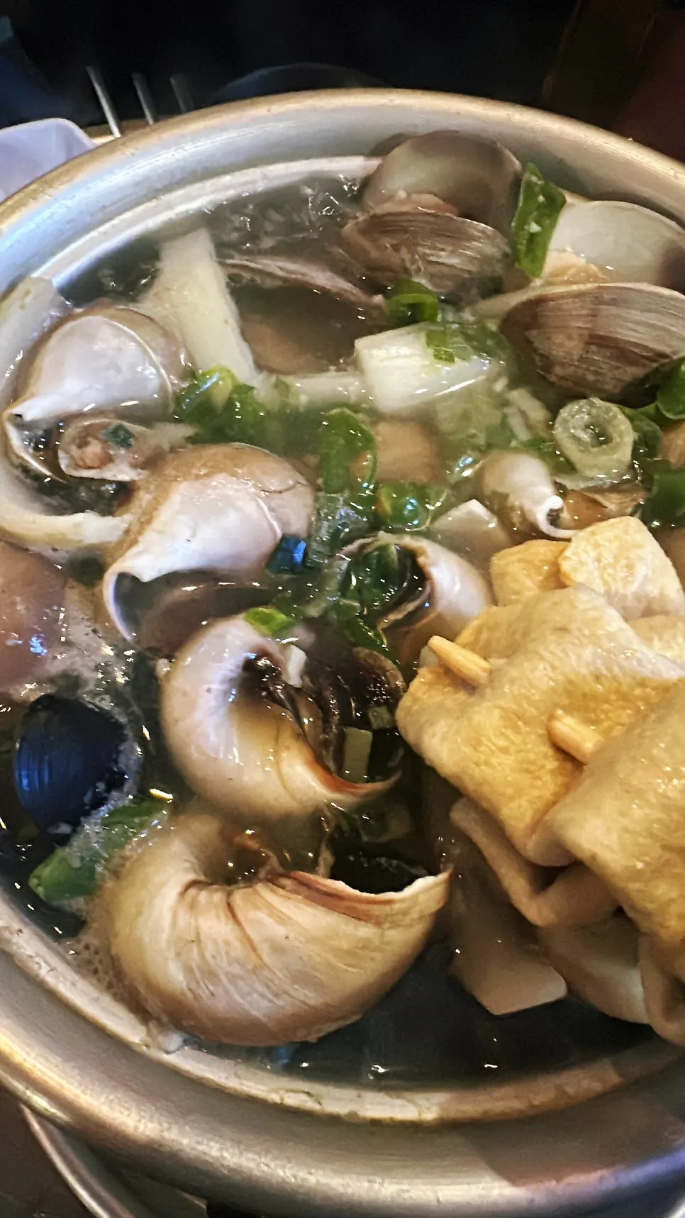 A spoonful of hot whelk hotpot broth