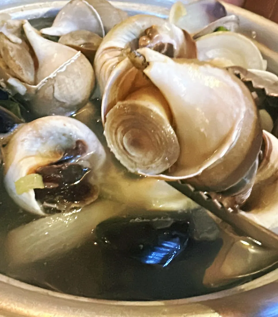Close-up of whelk and mussels in the broth