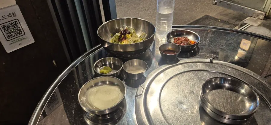 Table spread with garlic salt, soy sauce, and spicy chicken galbi plus salt-grilled chicken thigh