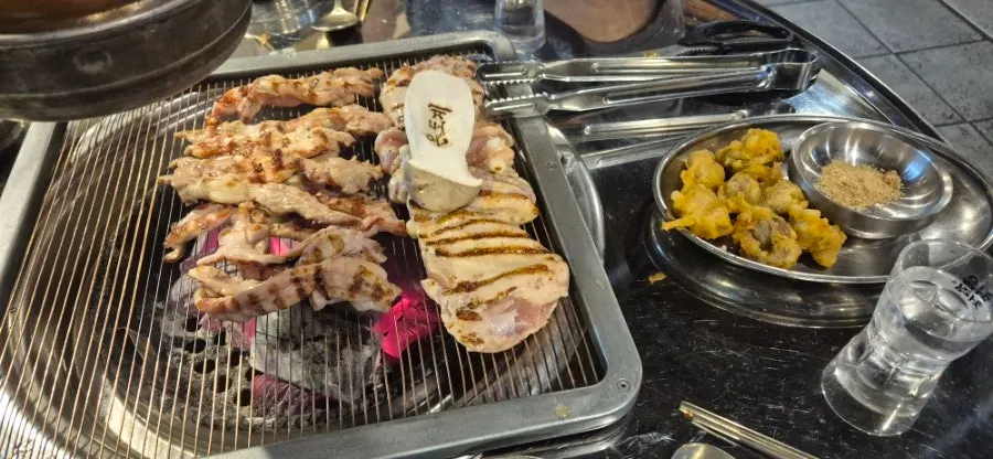 Chicken galbi being pre-grilled over charcoal