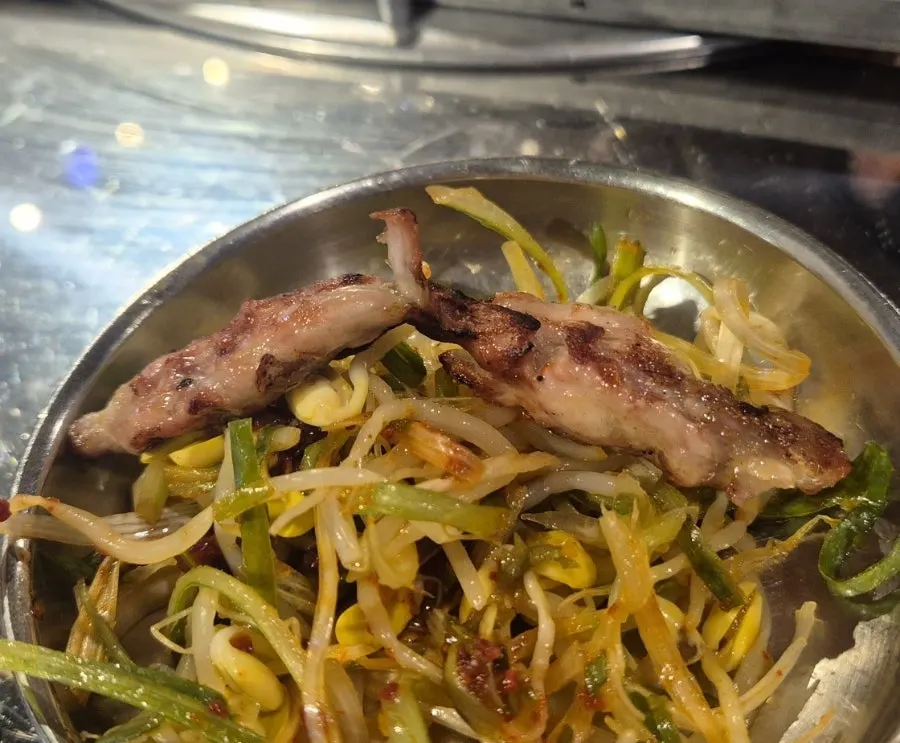 Staff finishing the chicken galbi on the charcoal grill