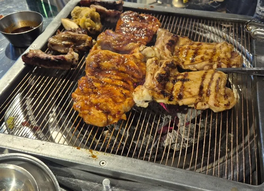 Close-up of chicken galbi cooking over charcoal