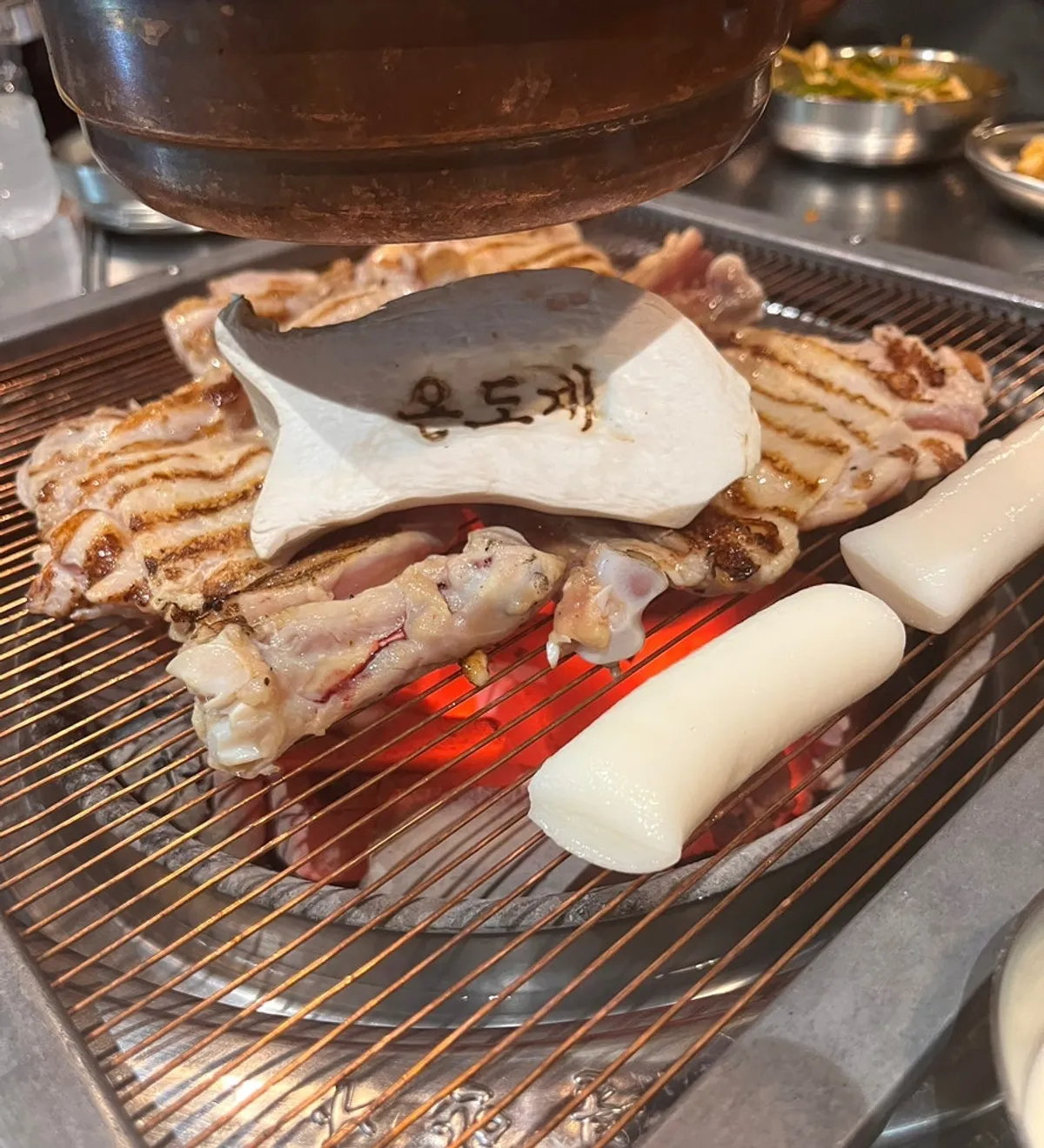 온도계 글자가 새겨진 새송이버섯과 떡이 올라간 불판