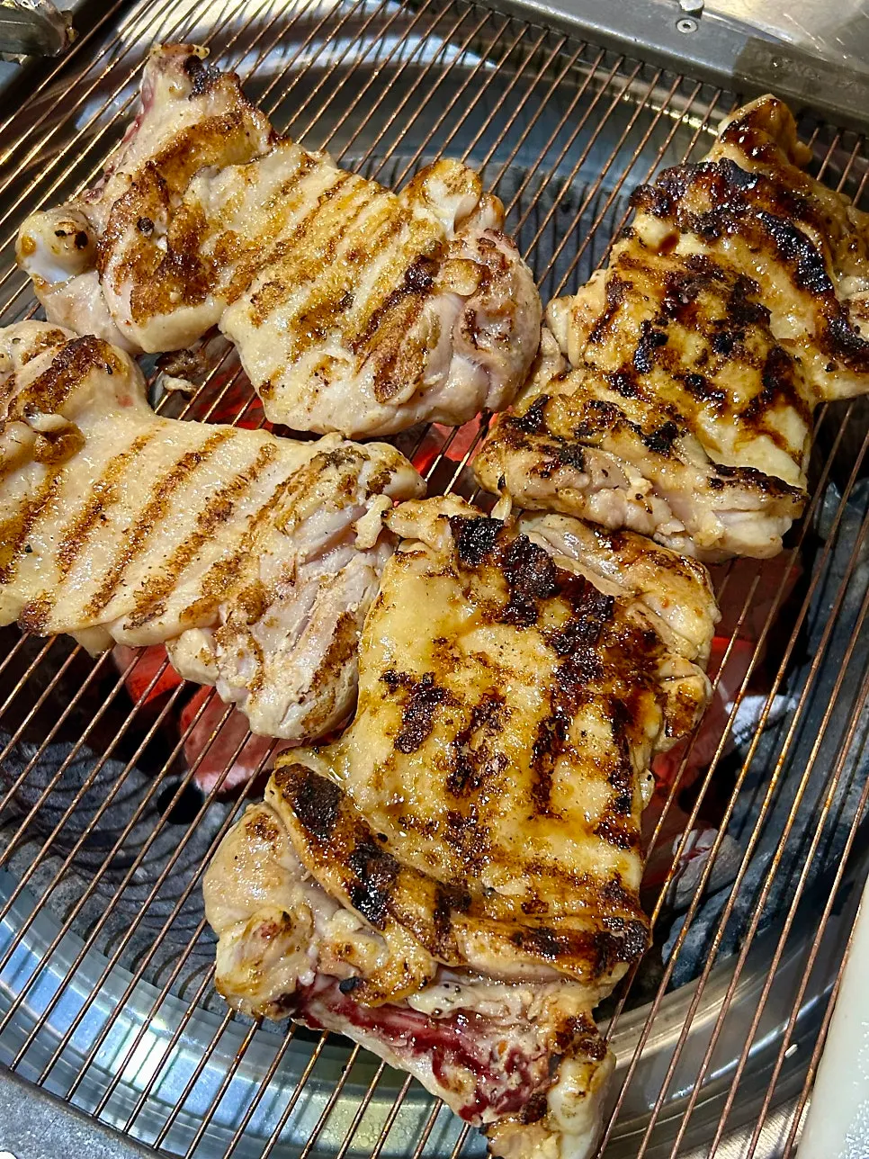 Chicken galbi and garaetteok cooking over the charcoal grill
