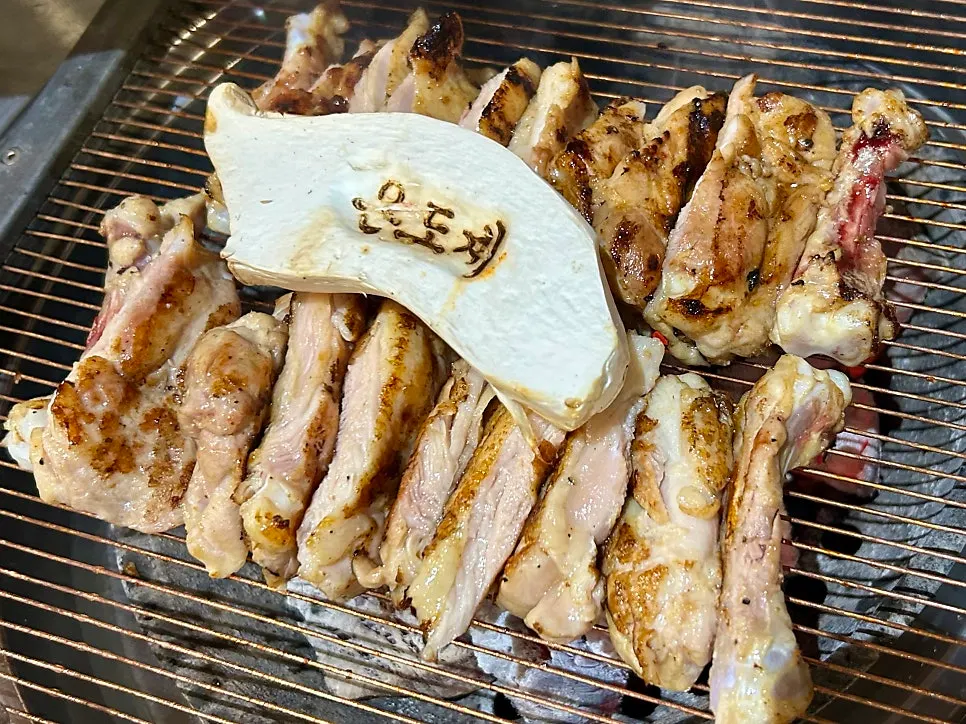 Staff member cutting and grilling the meat as part of the full-grilling service