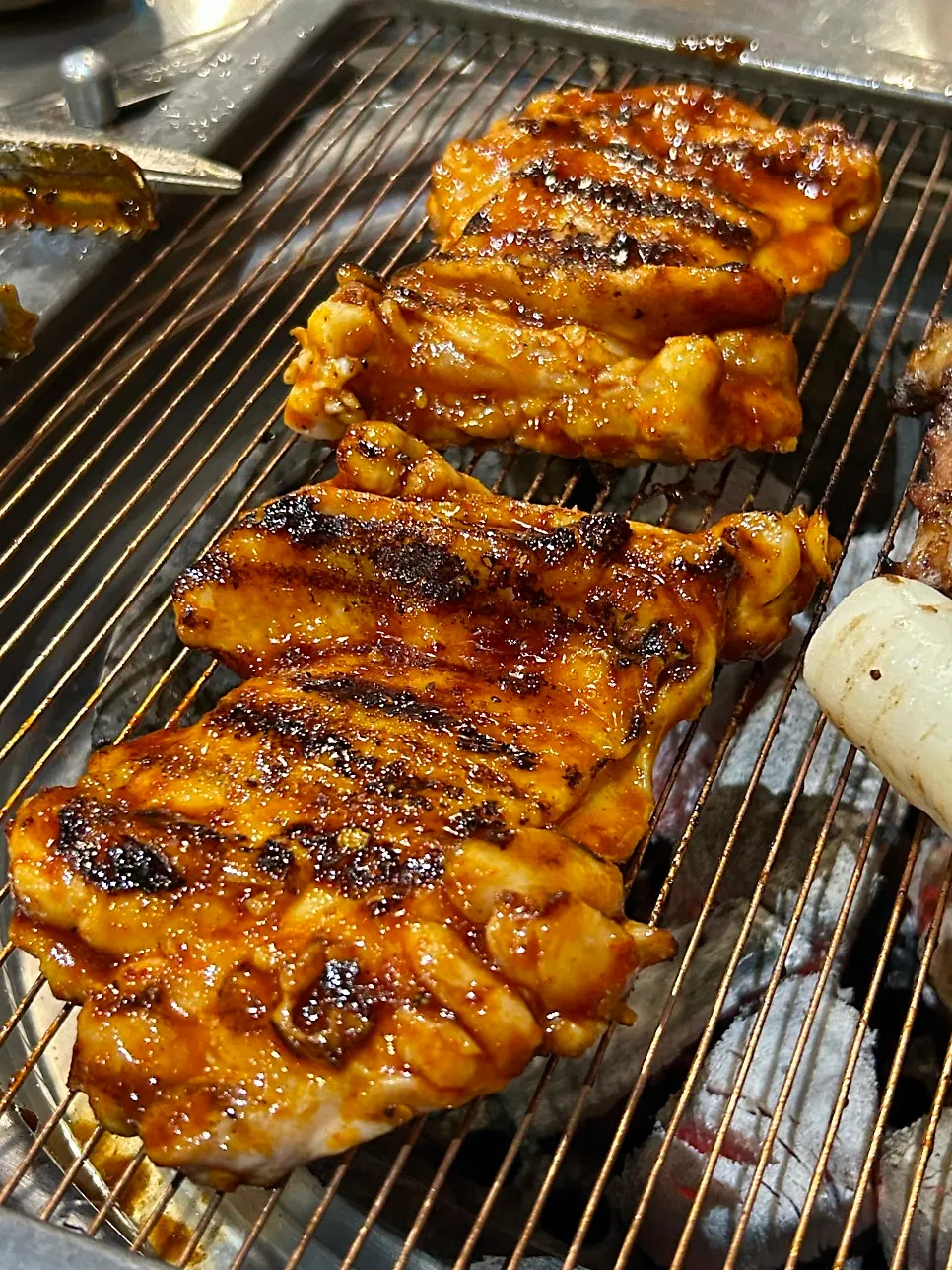 Spicy chicken galbi placed on the charcoal grill