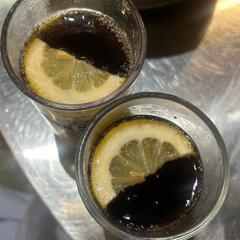 A glass of Coke served with a lemon slice