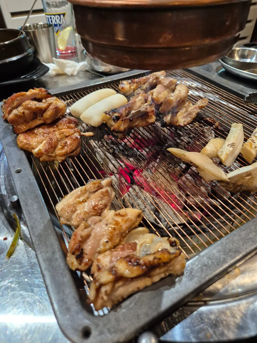 Close-up of chicken galbi cooking over charcoal