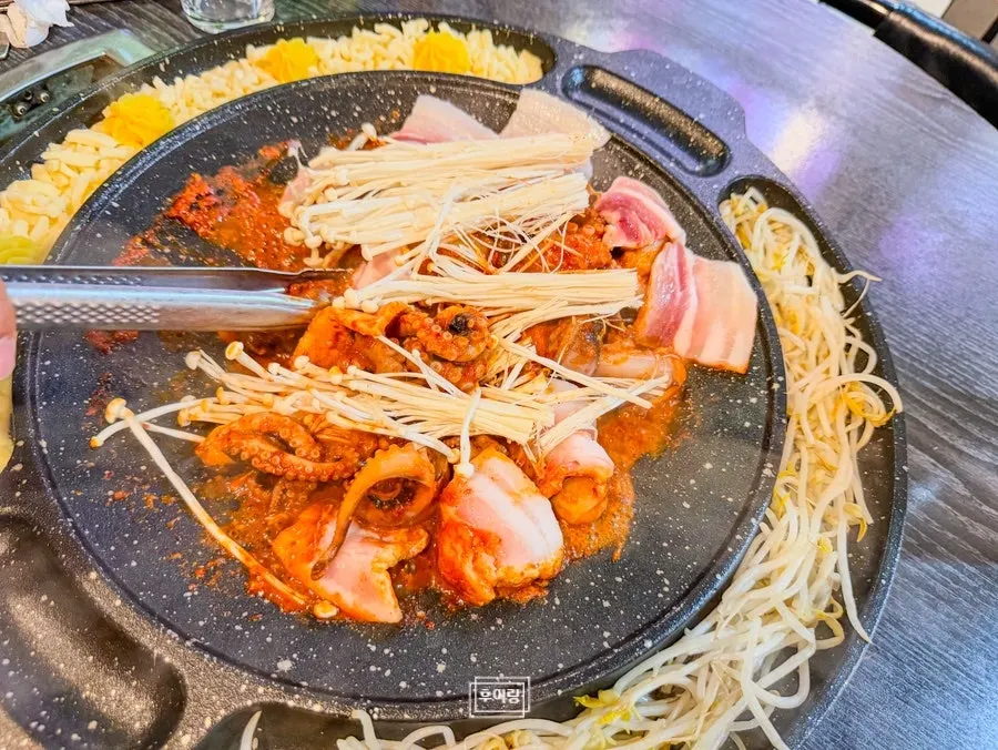 Octopus and pork belly stir-frying on the grill