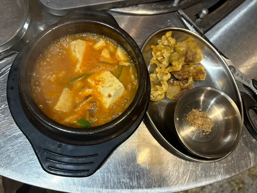 Complimentary doenjang jjigae and fried chicken gizzard