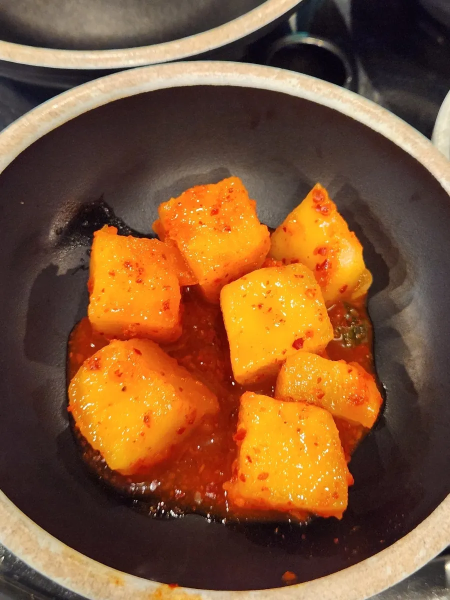 A spoonful of oso-ri gukbap with white rice stirred in