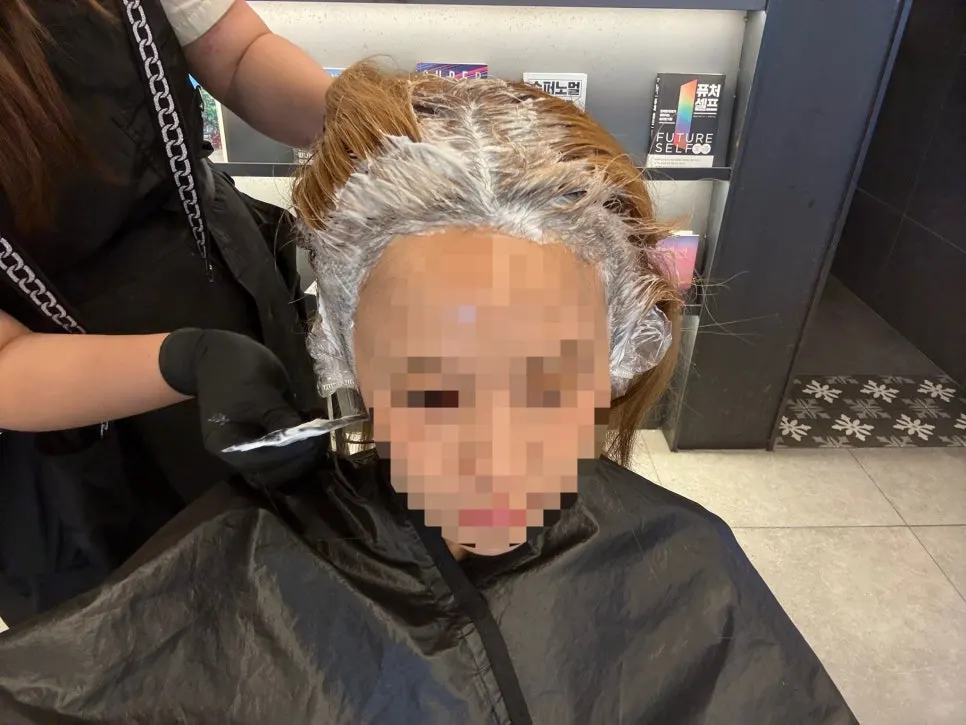 Root touch-up underway after applying scalp protector
