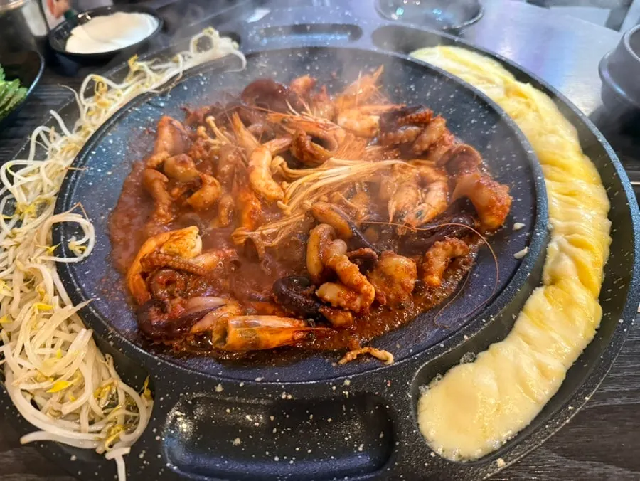 One griddle with jjukkumi, shrimp, cheese, and egg