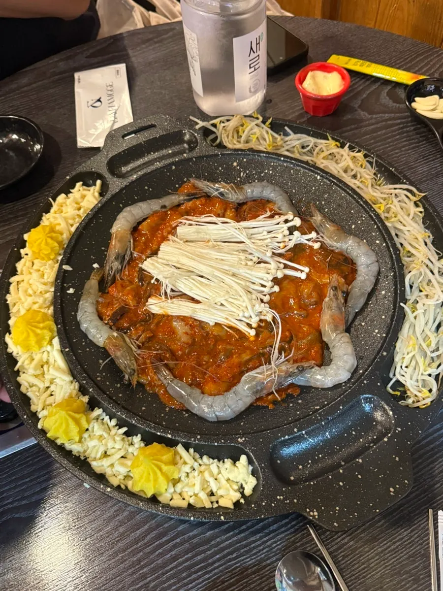 A griddle of spicy jjukkumi surrounded by shrimp
