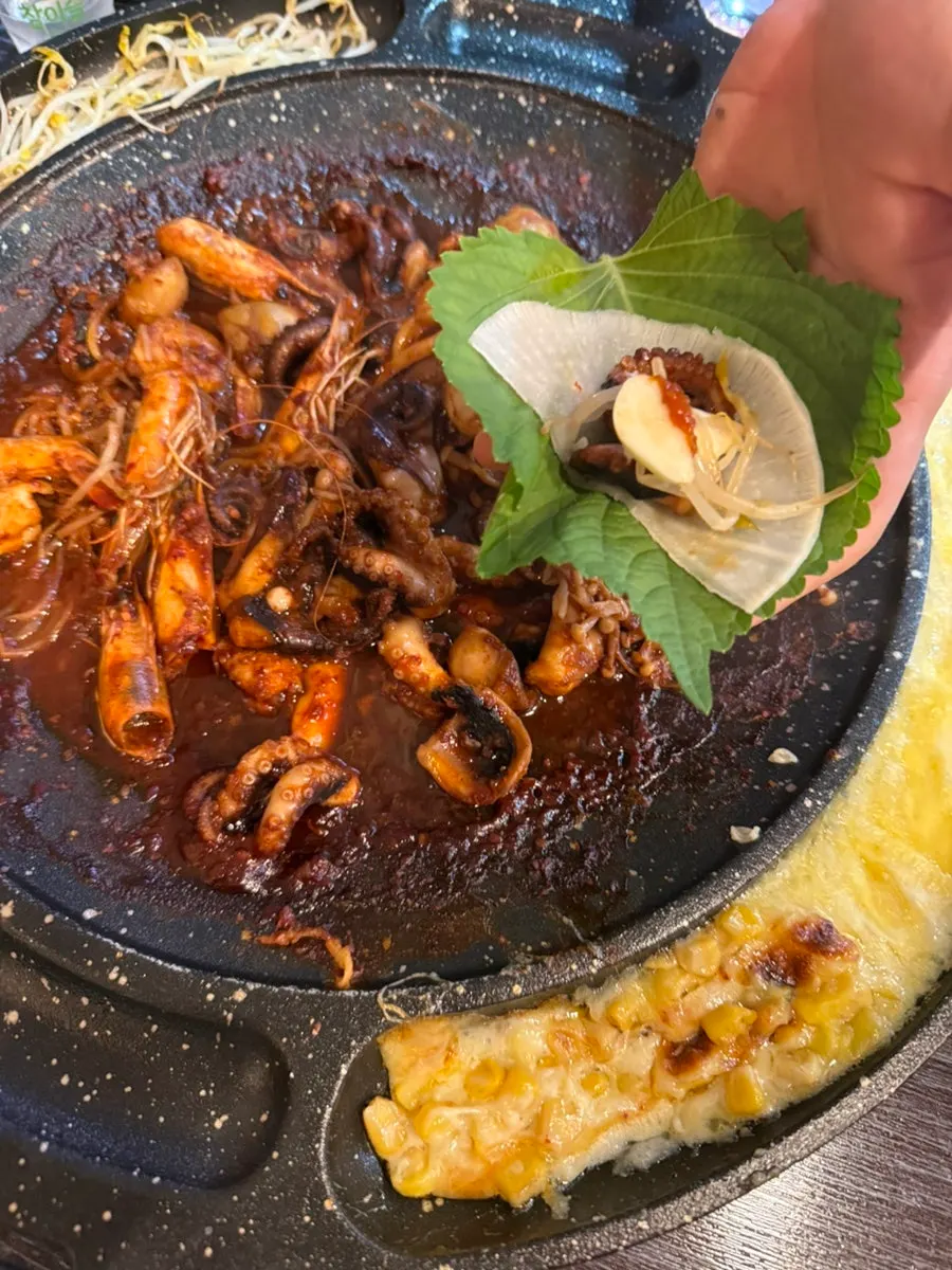 A wrap with perilla leaf, pickled radish, and jjukkumi