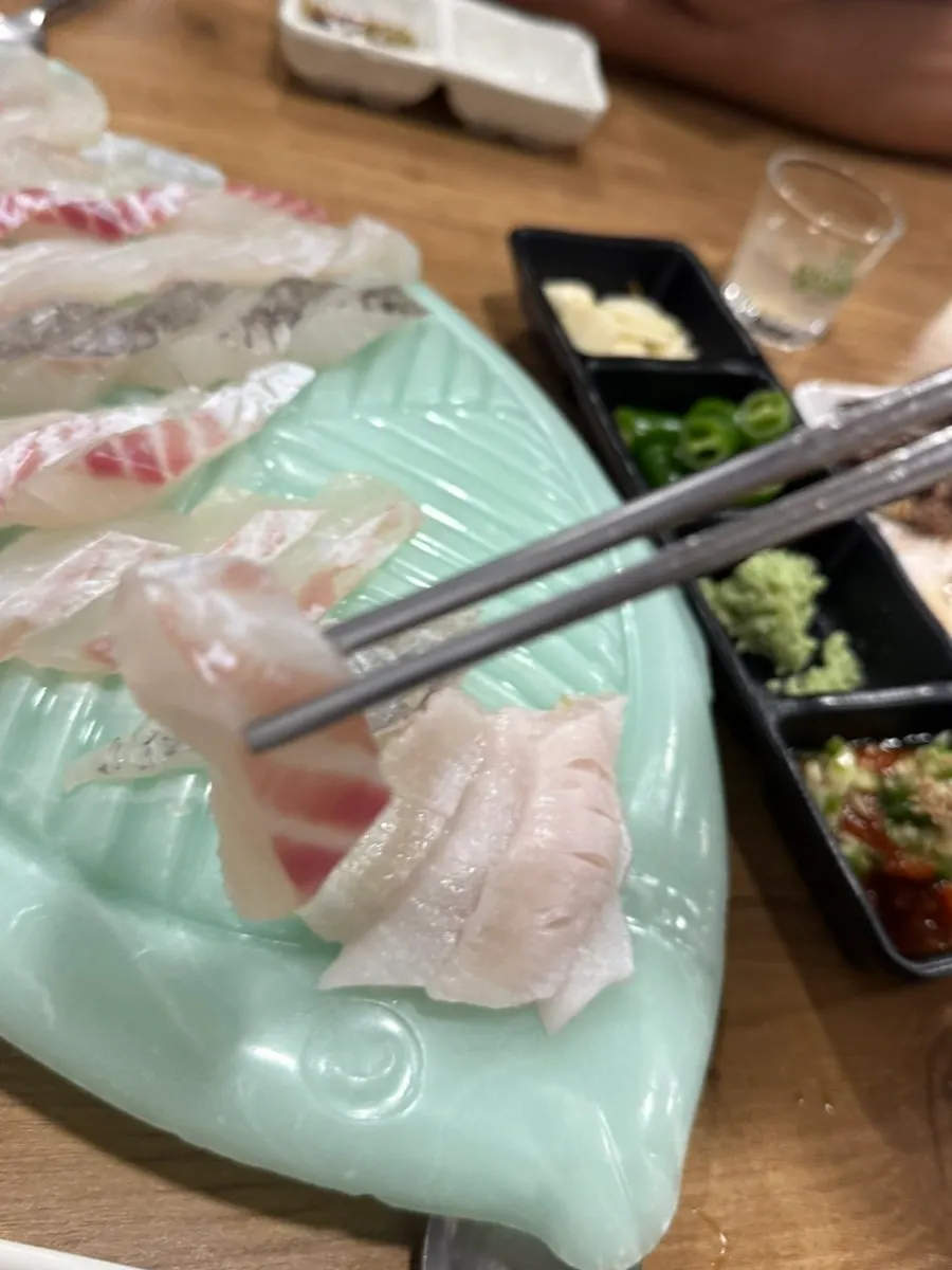 Halibut sashimi topped with wasabi