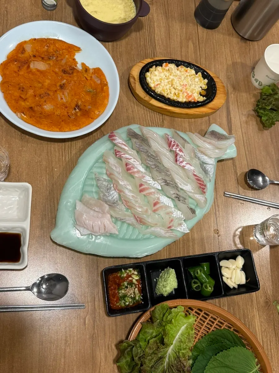 Table with raw fish, sides and soju