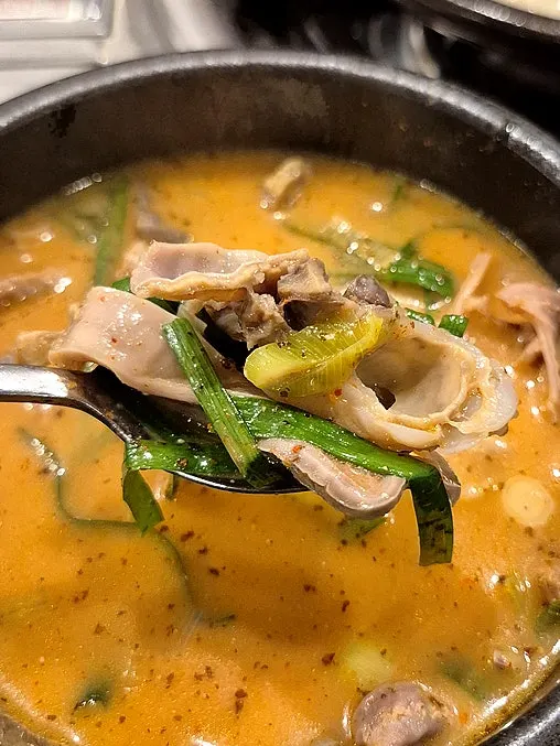 A spoonful of intestine gukbap with kimchi added