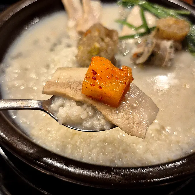 Pork jowl placed on rice soaked in the milky broth
