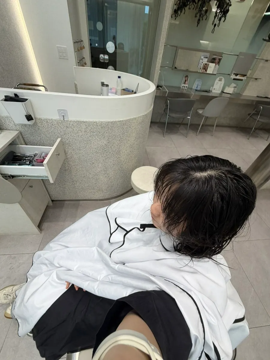 시술 가운을 두르고 커트 준비 중인 모습