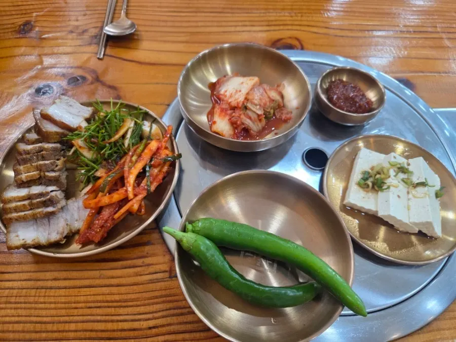 Basic side dish setting with kimchi, cucumber peppers, and tofu