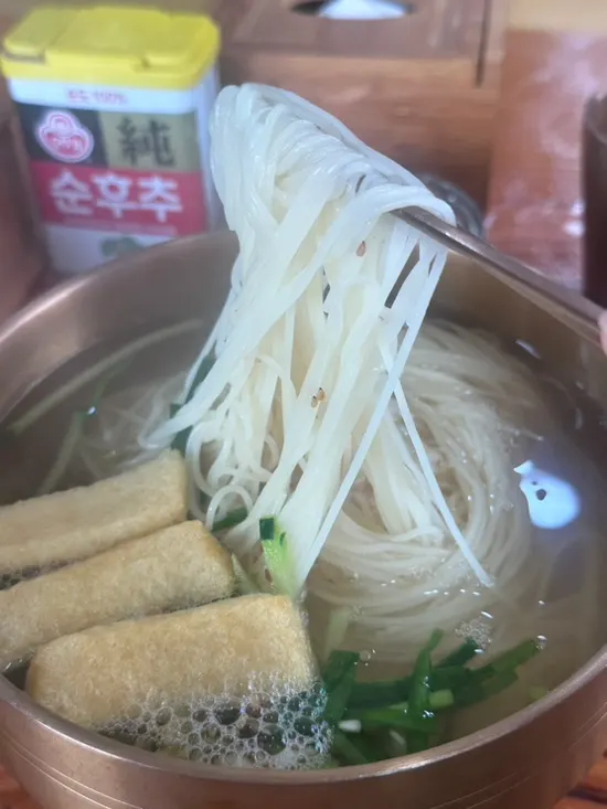 Janchi guksu broth topped with fried tofu and chives