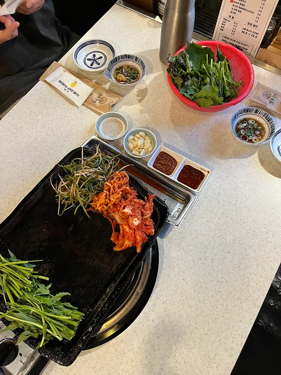 불판에 올린 삼겹살과 미나리, 파채
