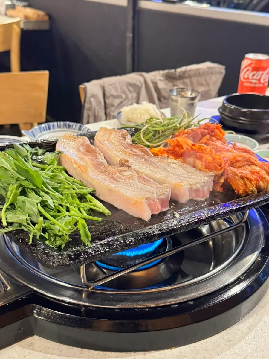 미나리와 김치를 함께 올려 굽는 삼겹살