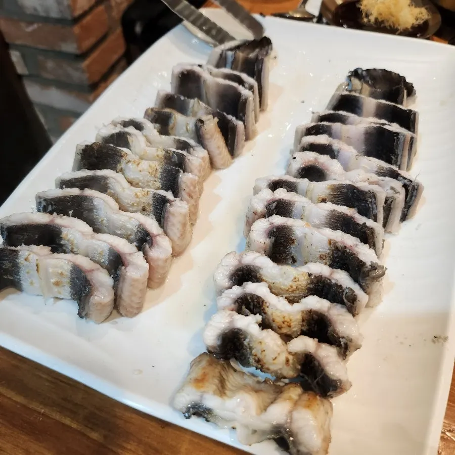 Staff member searing eel over white charcoal