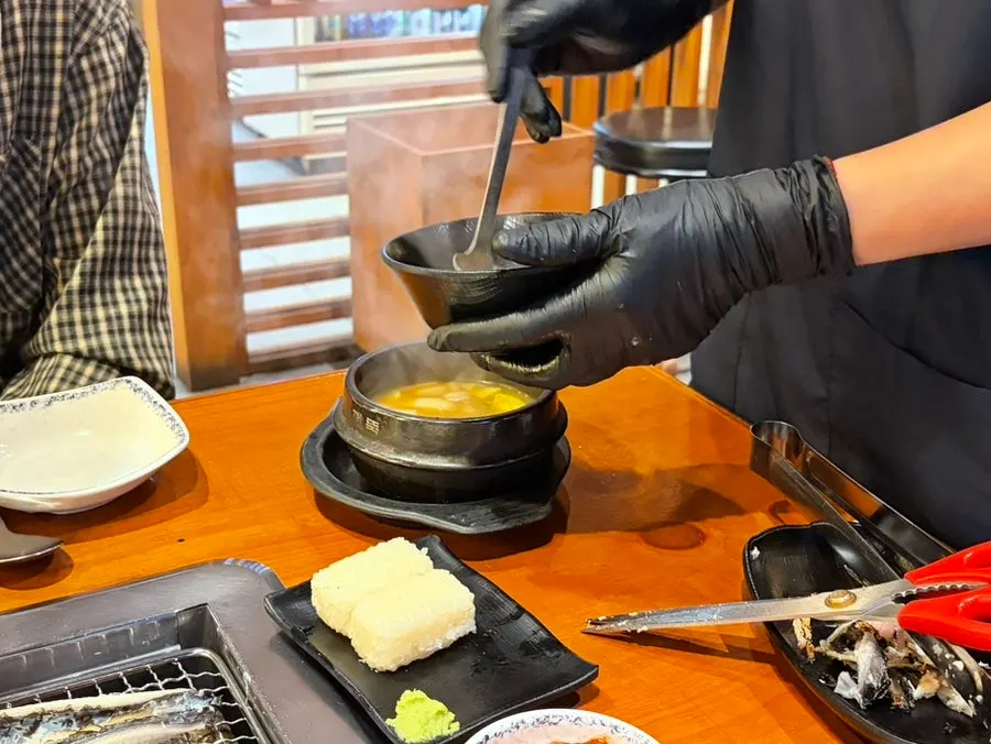 Staff member grilling eel over charcoal