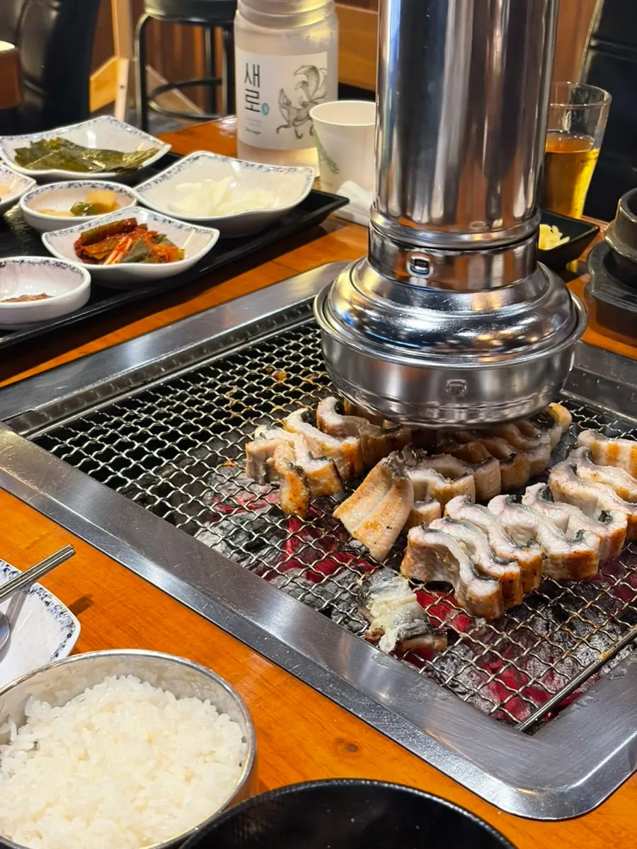 Staff member skillfully prepping and grilling the eel