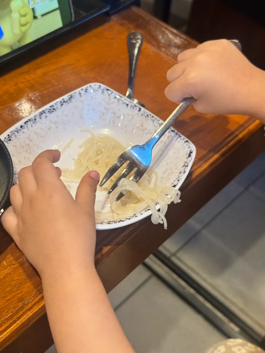 The toddler eating rice in a baby chair