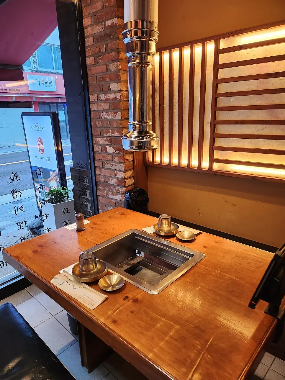 Charcoal grill table equipped with a smoke ventilation duct